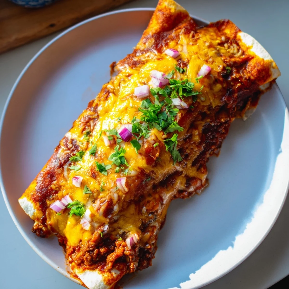 Steaming hot Beef Enchiladas with melted cheese, glistening with rich red sauce, ready to serve with fresh cilantro.