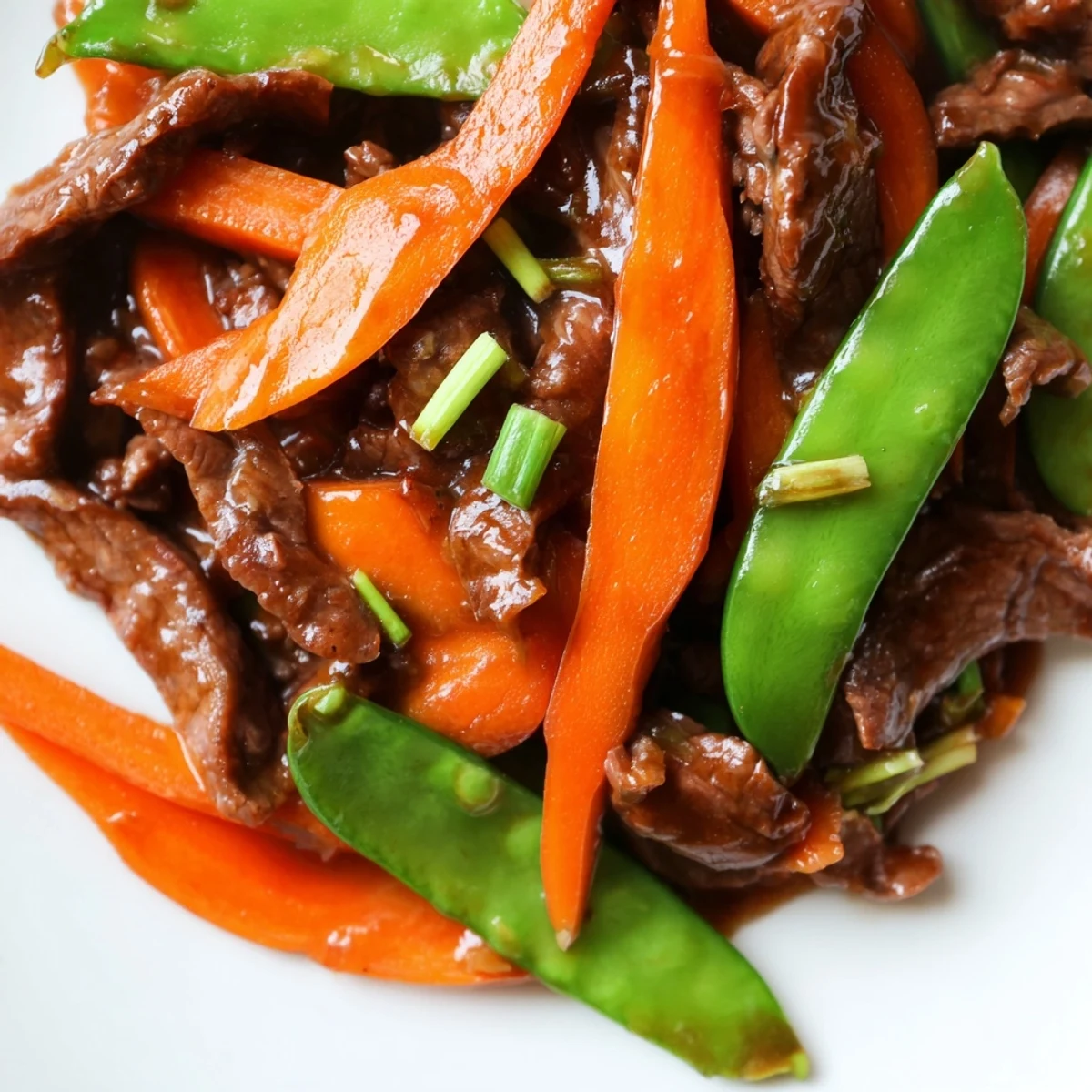 Beef Stir Fry with Snow Peas and Carrots served over fluffy white rice with chopsticks ready for a quick weeknight meal.