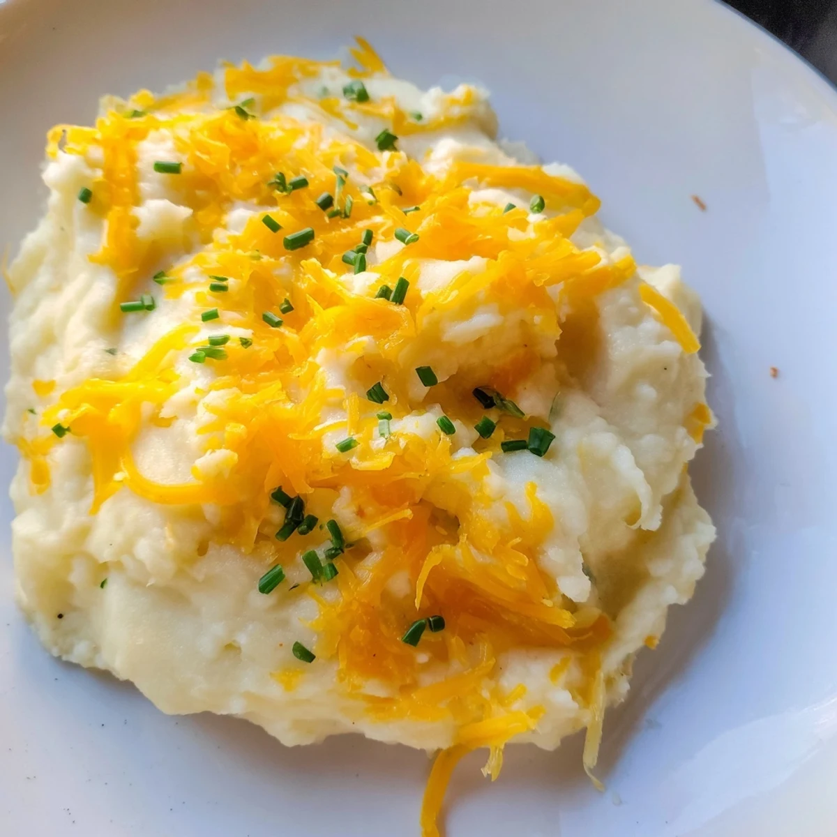 Smooth Garlic Mashed Cauliflower with Cheese melted over tender florets and roasted garlic cloves.