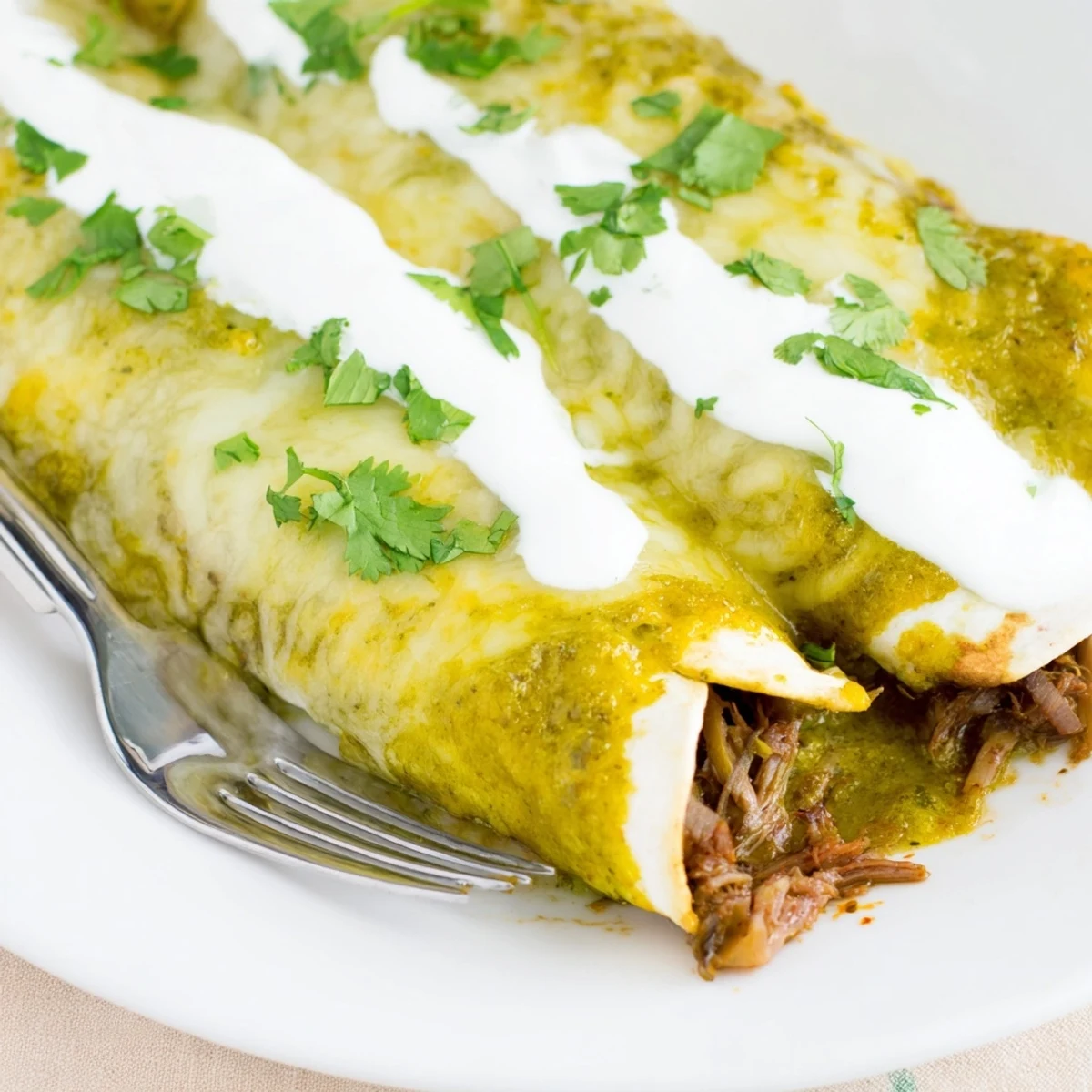 Beef Enchiladas with Green Sauce baked golden brown, smothered in tangy tomatillo sauce and melted Monterey Jack cheese.