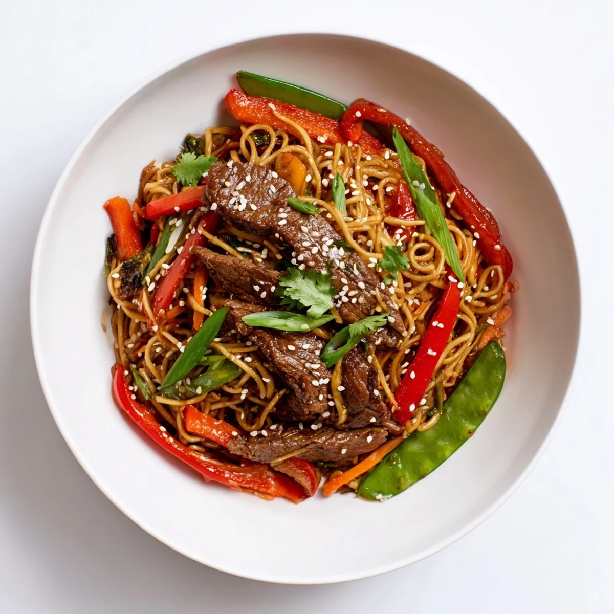 A steaming serving of Spicy Beef Stir Fry with Noodles in a white bowl, garnished with fresh cilantro and toasted sesame seeds for a flavorful weeknight dinner.