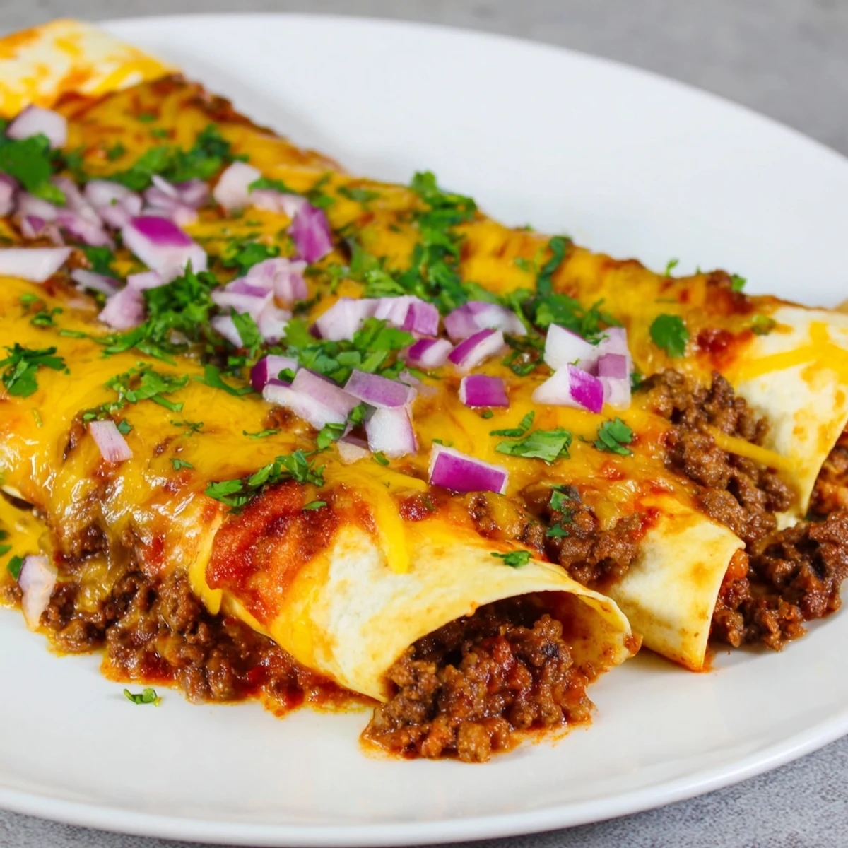 Golden-brown Championship Beef Enchiladas with Red Sauce, bubbling with melted cheese and garnished with fresh cilantro.