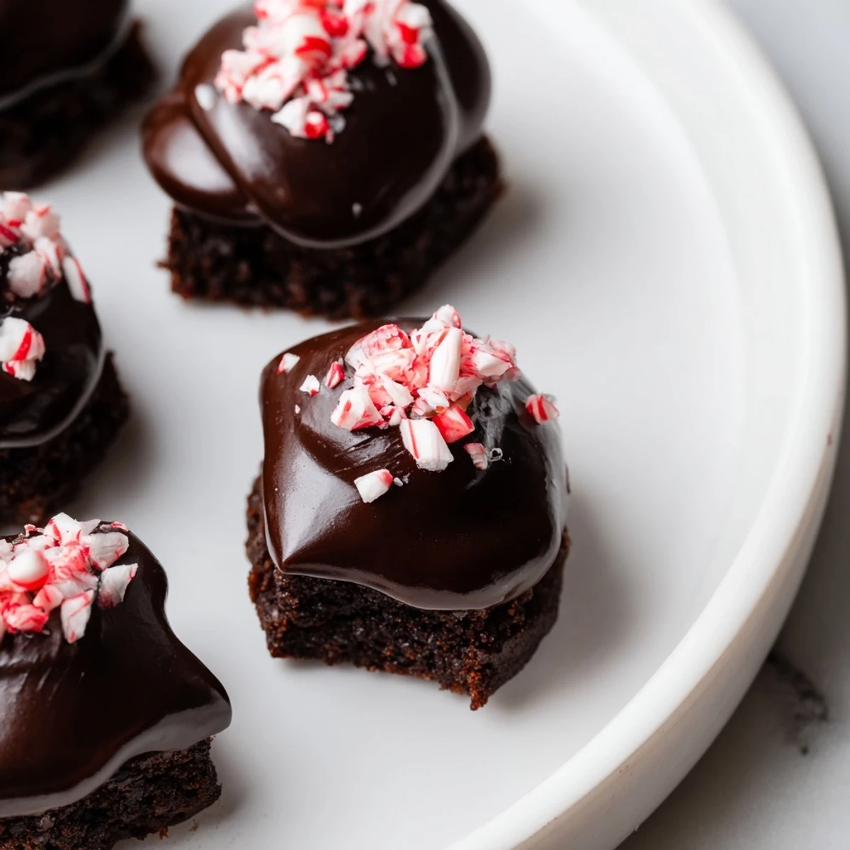 Cool mint brownie bites with a velvety chocolate ganache glaze, paired with a glass of milk.