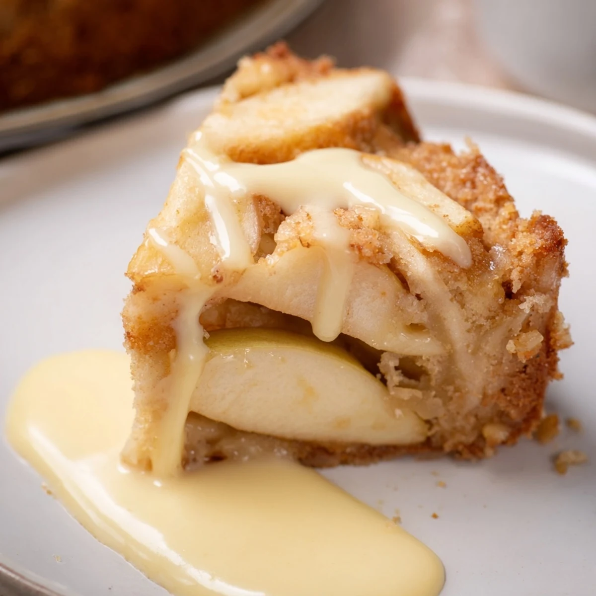 Homemade Irish Apple Cake with Custard on a wooden table, garnished with apple slices and a dusting of powdered sugar, ready to serve.