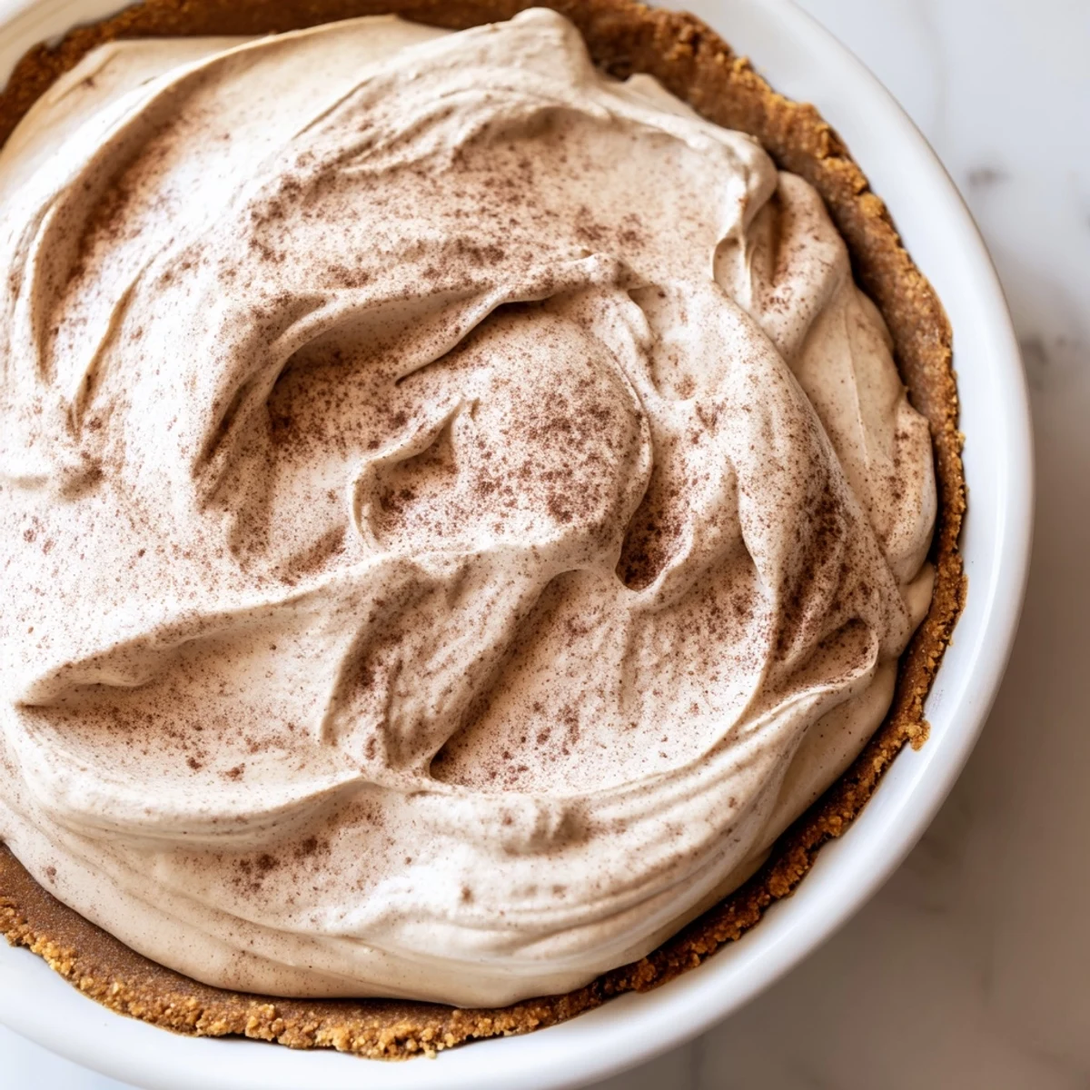 A beautiful keto cold brew coffee pie with velvety texture and coffee bean garnish on a plate.