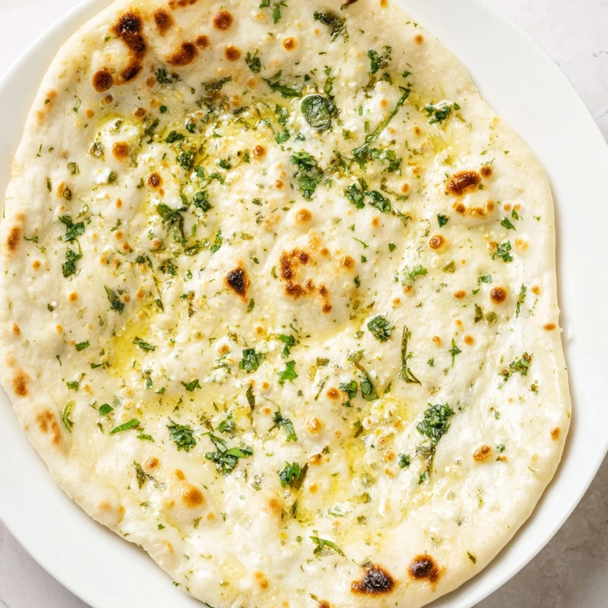 Golden Cottage Cheese Garlic Naan split open to reveal creamy cottage cheese filling, paired with a side of cooling raita.