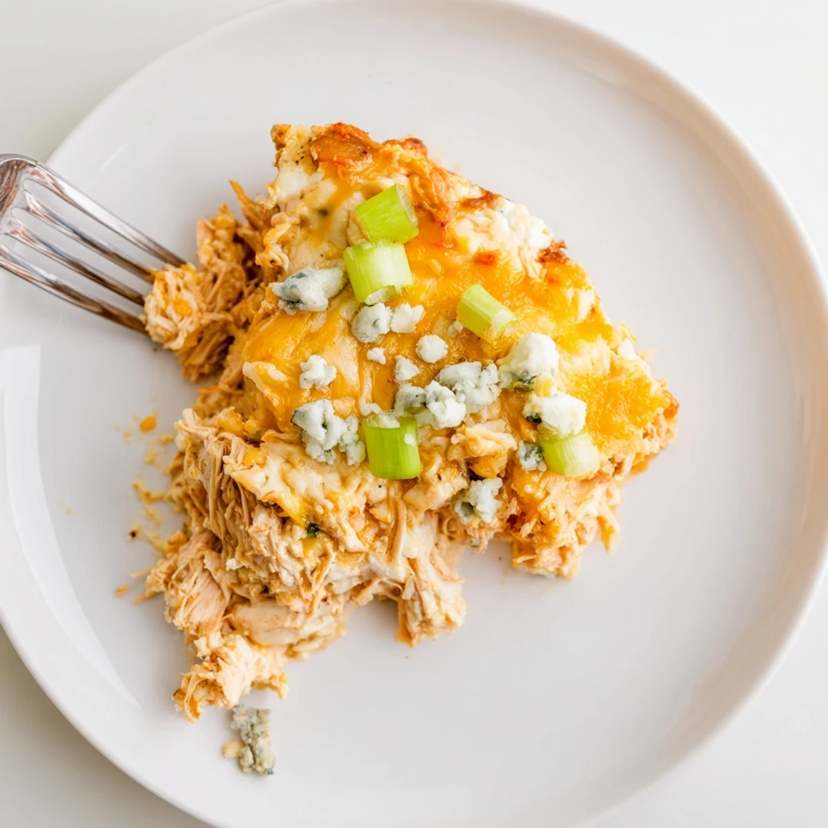 Golden, bubbly Keto Buffalo Chicken Dip fresh from the oven, garnished with fresh green onions.