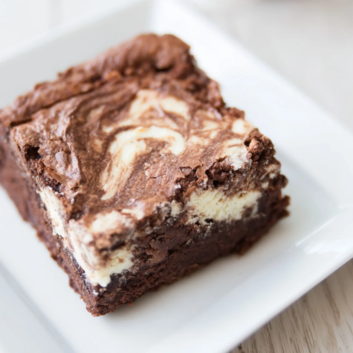 Warm, fudgy Cottage Cheese Brownies with a marbled creamy swirl on a rustic wooden table.  