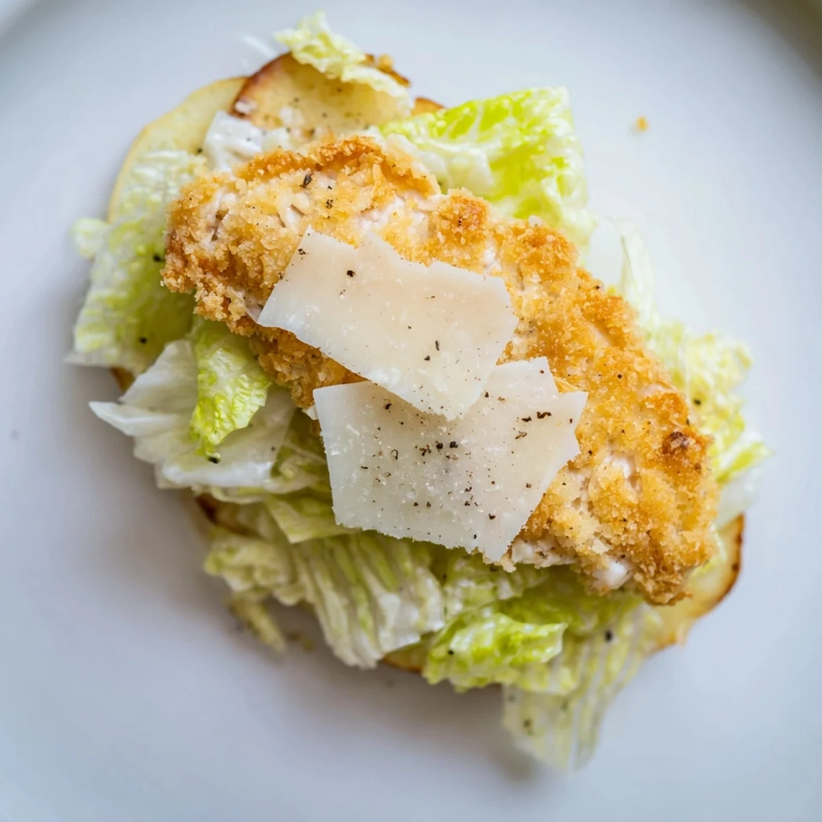 Golden, crunchy homemade potato chips topped with Crispy Chicken Caesar Salad ingredients like romaine, parmesan, and Caesar dressing.