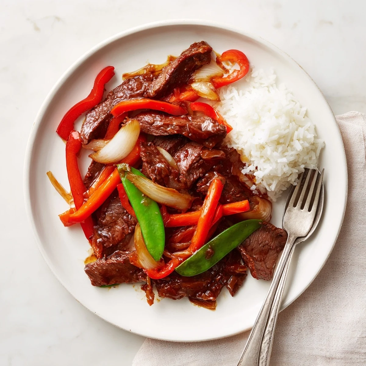 Tender strips of Beef With Oyster Sauce glisten next to snow peas and red bell pepper.