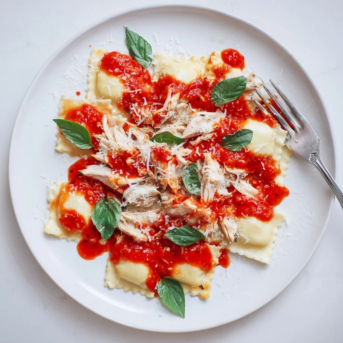 A rustic wooden table holds a bowl of Chicken and Mushroom Ravioli with Simple Tomato Sauce, steam rising from the bright red sauce.