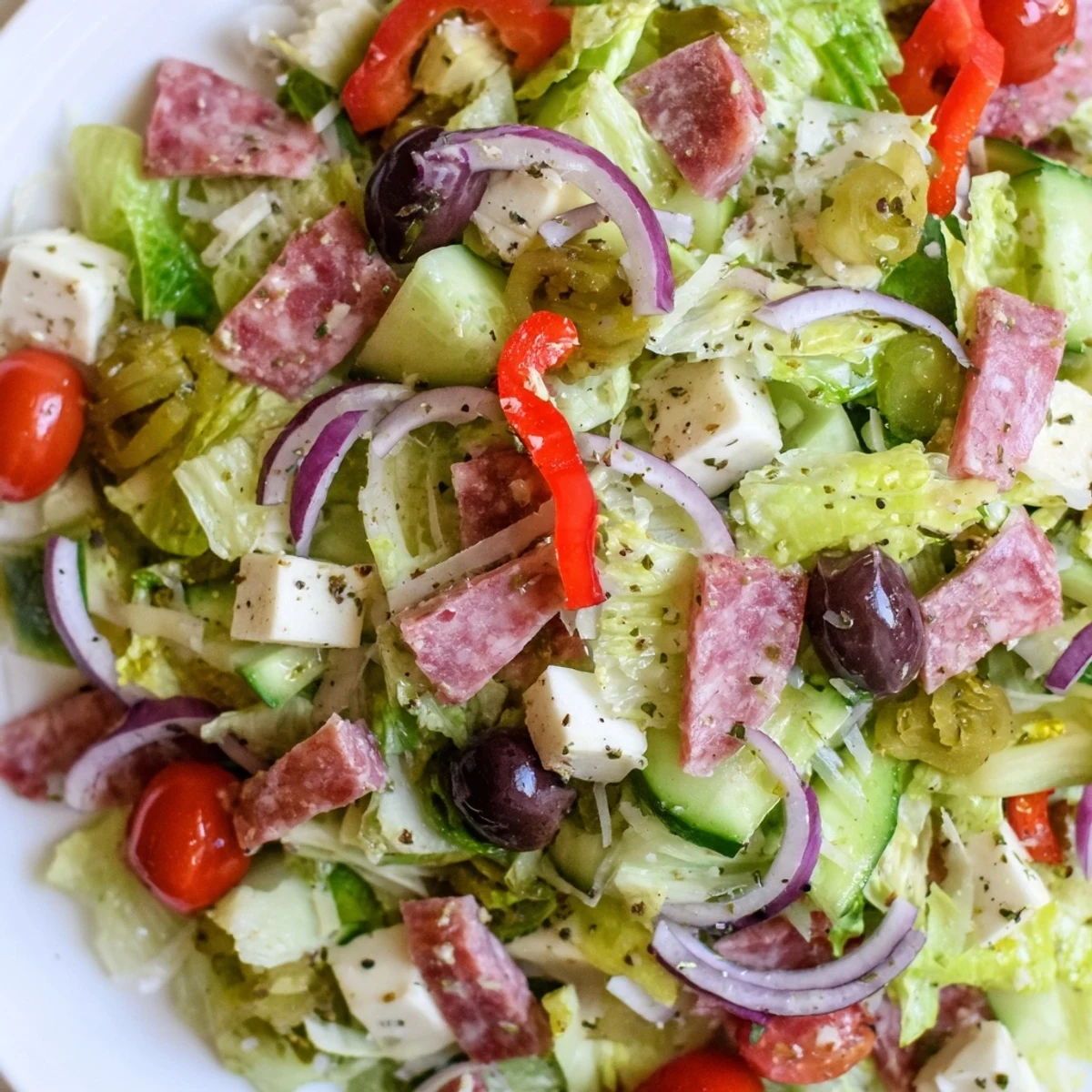 Colorful bowl of Italian chopped salad featuring mozzarella, pepperoncini, tomatoes, and zesty homemade Italian dressing