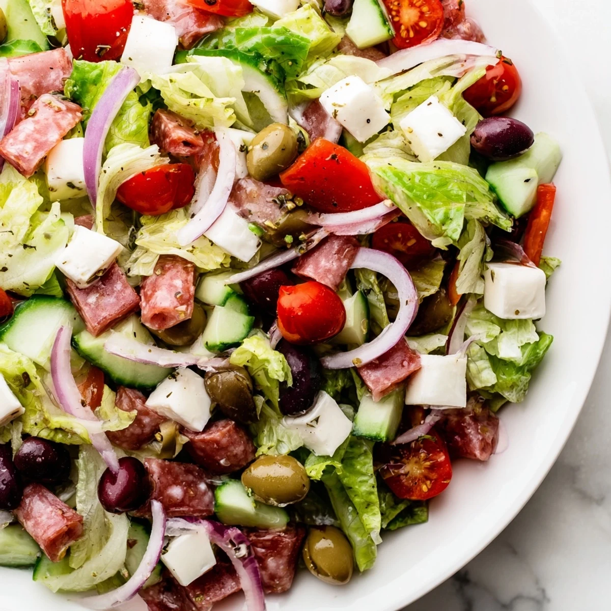 Vibrant Italian chopped salad tossed in homemade dressing with Genoa salami, roasted peppers, and shaved Parmesan cheese
