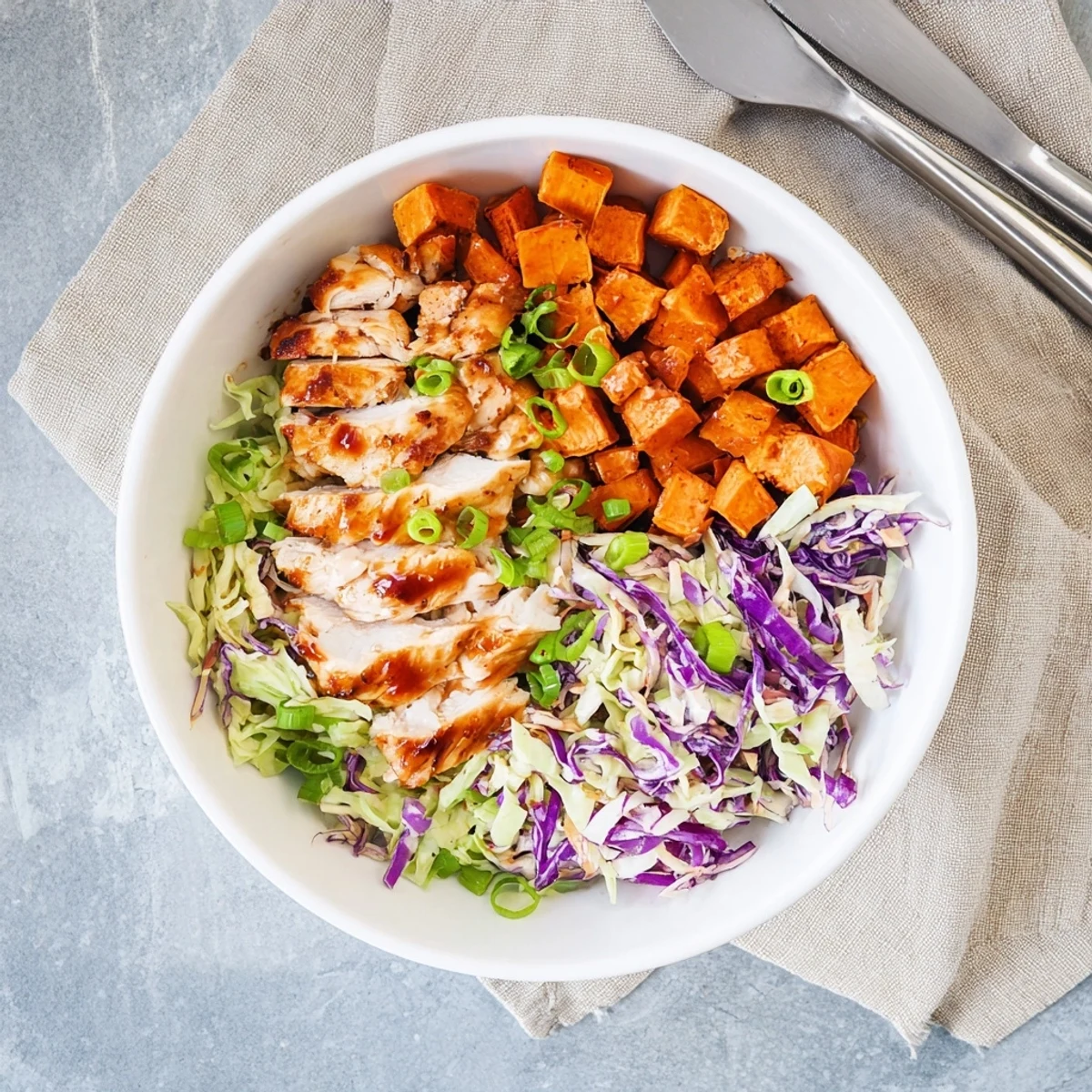 Hearty BBQ chicken bowl with roasted sweet potatoes and colorful coleslaw ready for serving