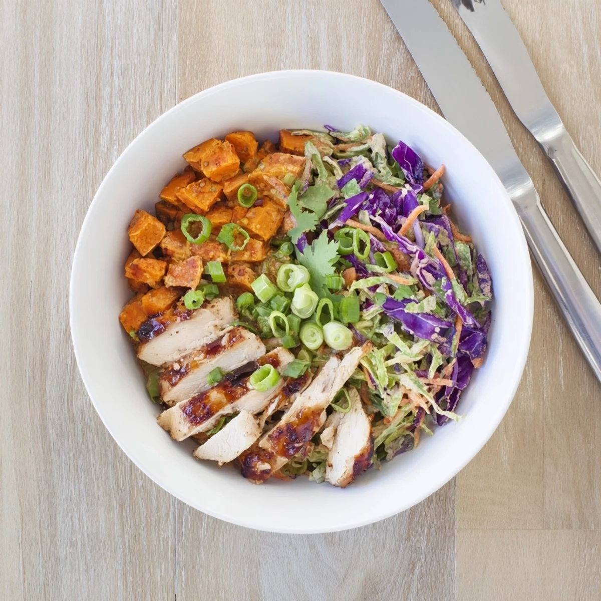Glazed sliced chicken breast over crispy purple and green cabbage slaw with tender sweet potato cubes