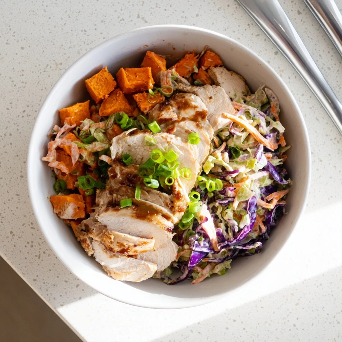 Flavor-packed meal prep bowl featuring juicy BBQ chicken, roasted sweet potatoes, and fresh crunchy coleslaw