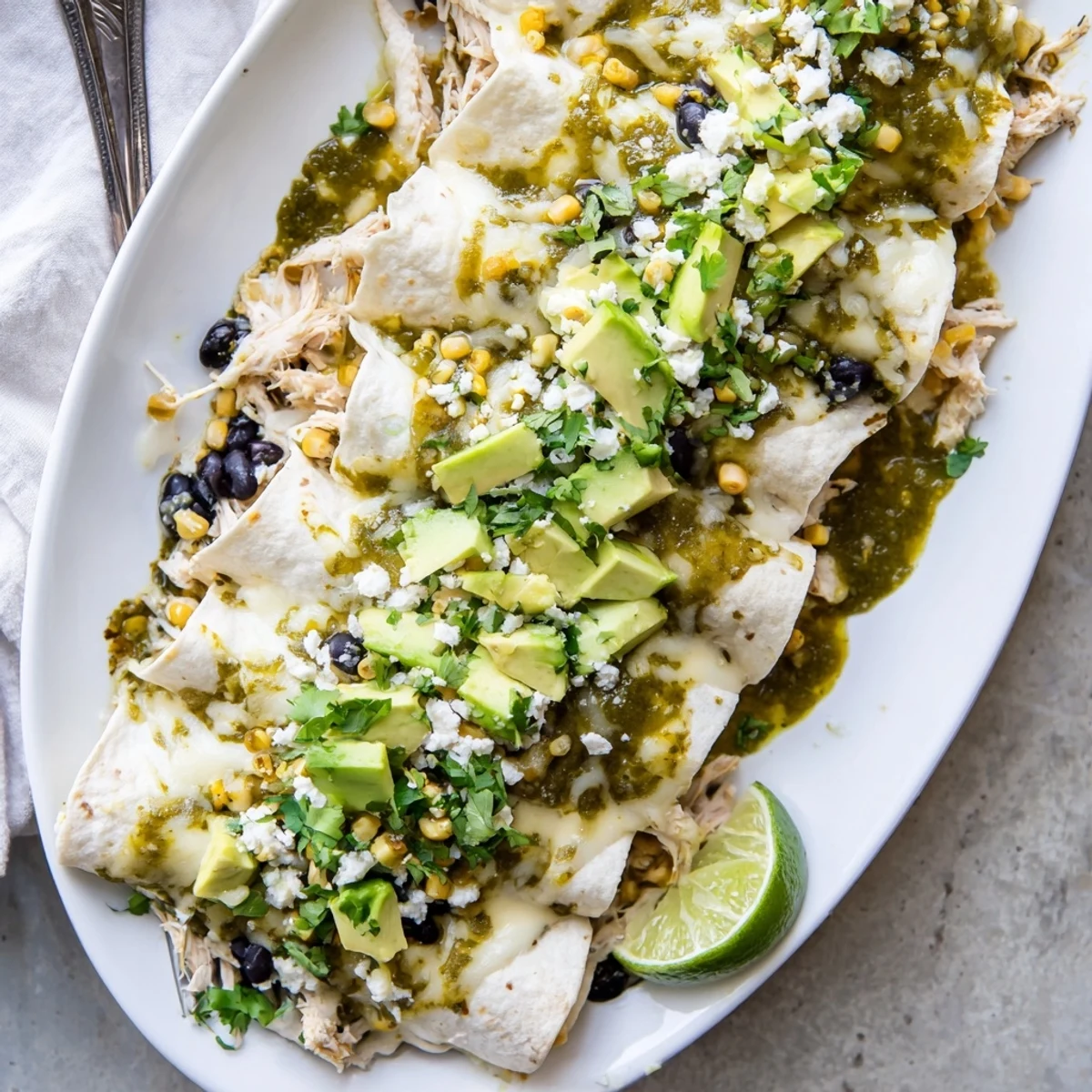 Golden salsa verde chicken enchiladas topped with melted Monterey Jack cheese and fresh cilantro garnish