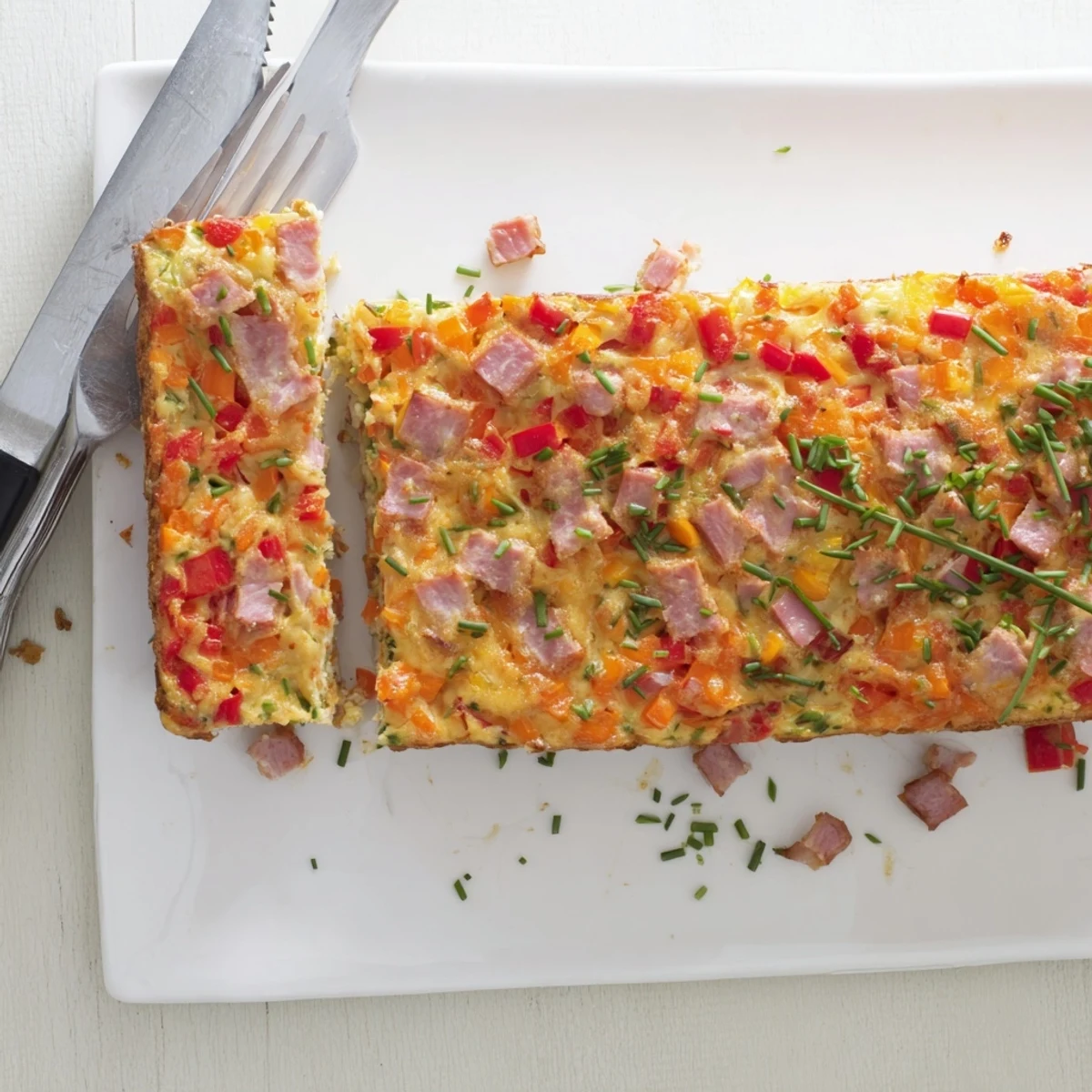Golden vegetable and ham slice freshly baked with colorful diced peppers and shredded carrots