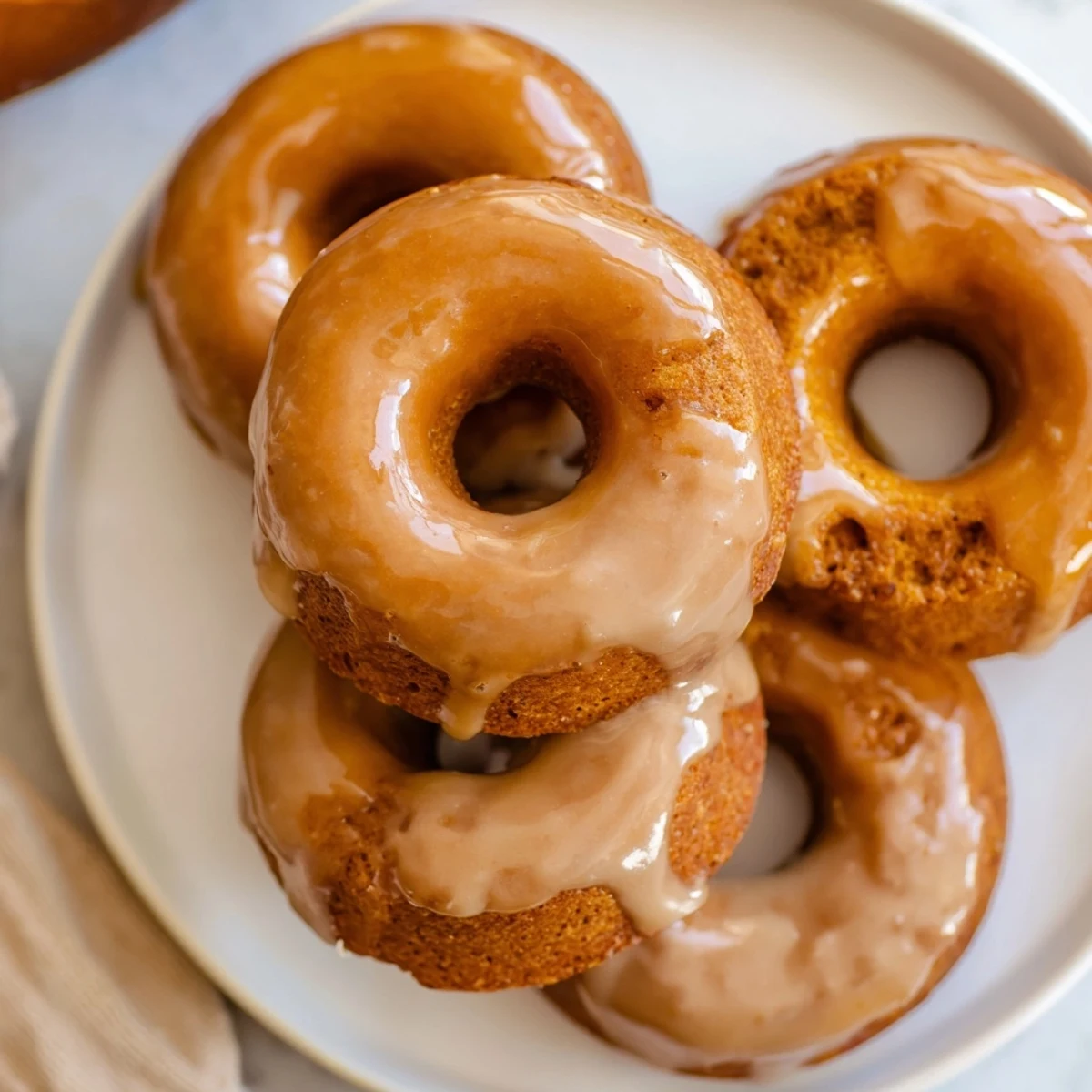 Soft chewy maple pumpkin mochi donuts freshly baked and dipped in sweet maple glaze for fall dessert