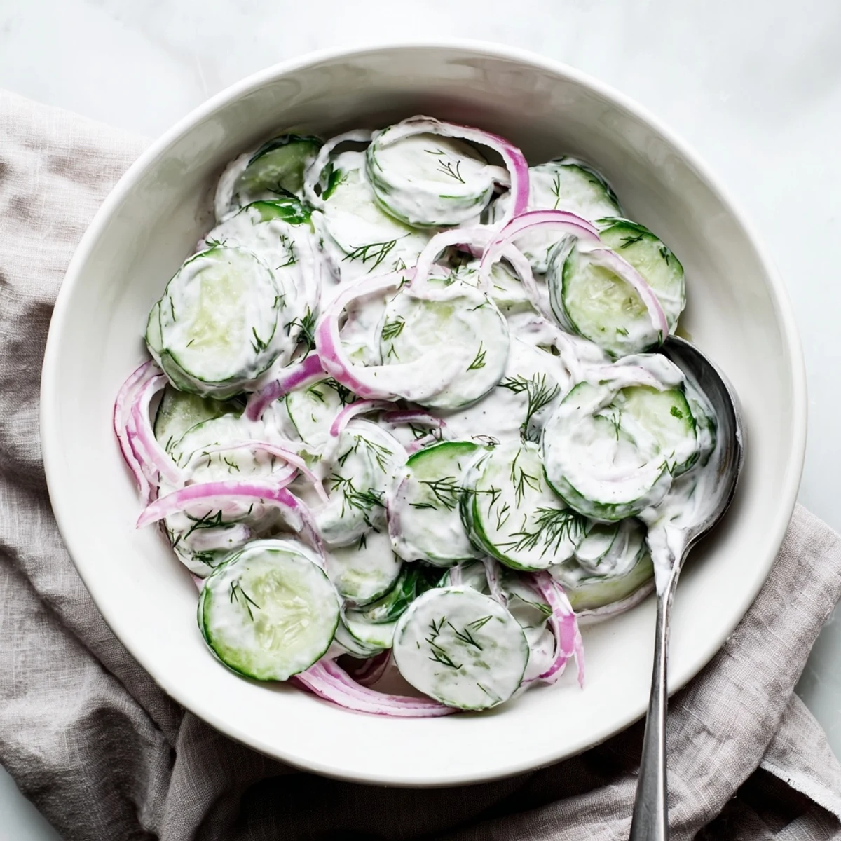 Fresh creamy cucumber salad featuring thin cucumber rounds coated in herbed sour cream sauce