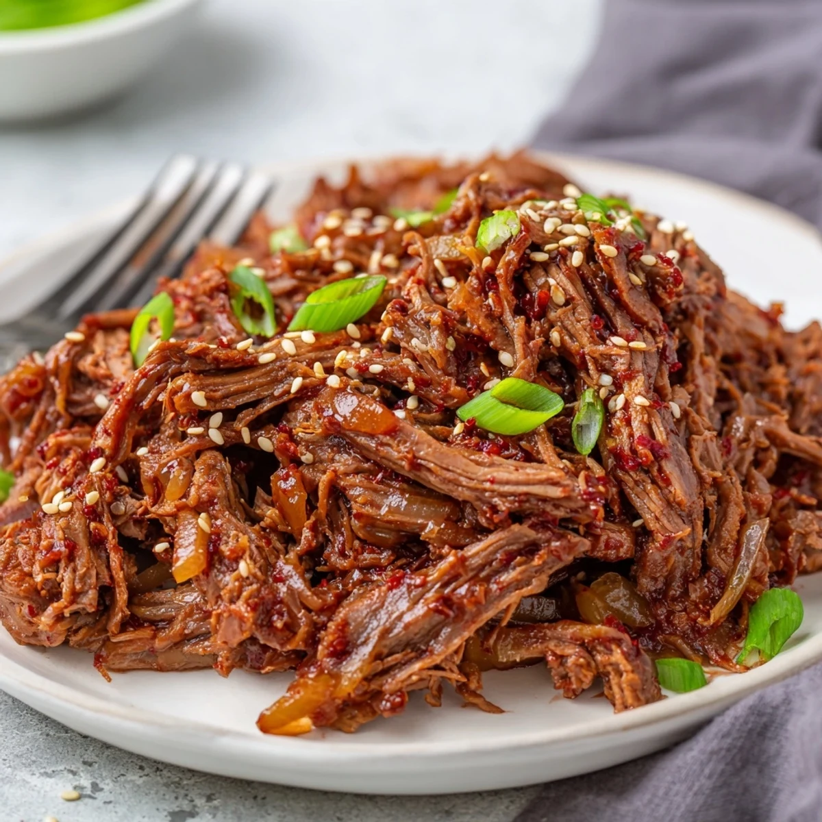 Garnished slow cooker Korean beef served over steamed white rice with fresh green onions