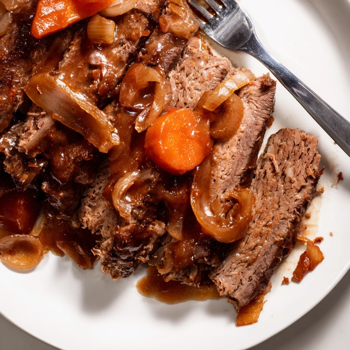 Fork-tender slow cooker beef brisket sliced and plated with roasted carrots and celery
