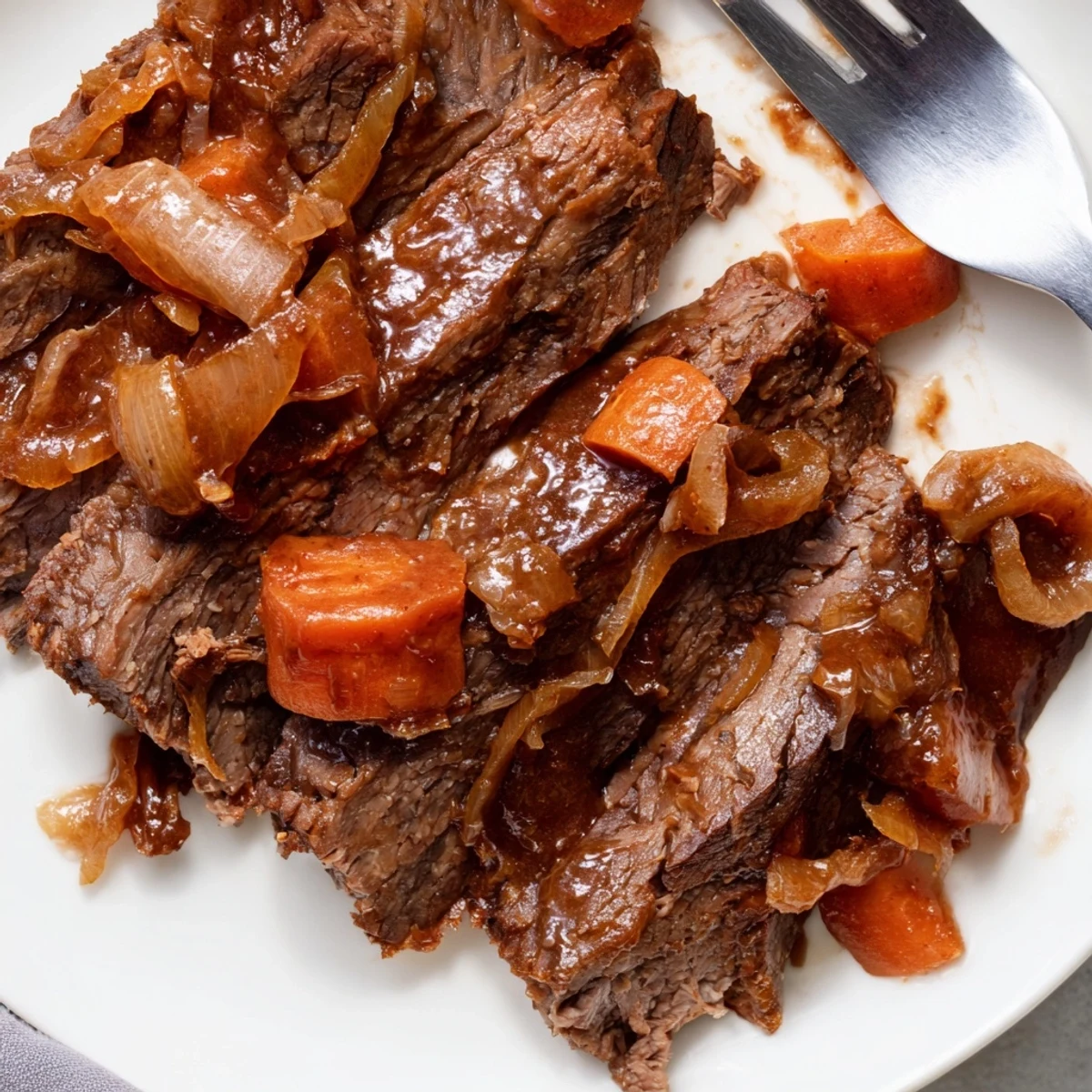 Juicy slow cooker beef brisket resting in a dark glossy sauce with aromatic vegetables