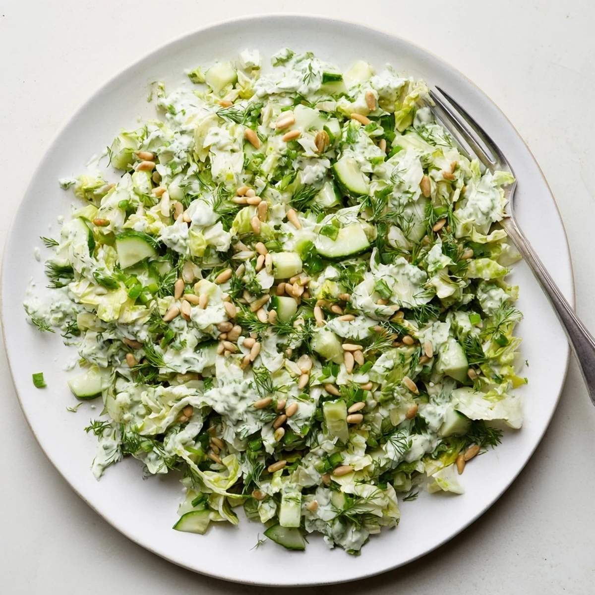 Creamy Green Goddess Salad featuring crisp romaine cucumber and chives topped with sunflower seeds and zesty dressing