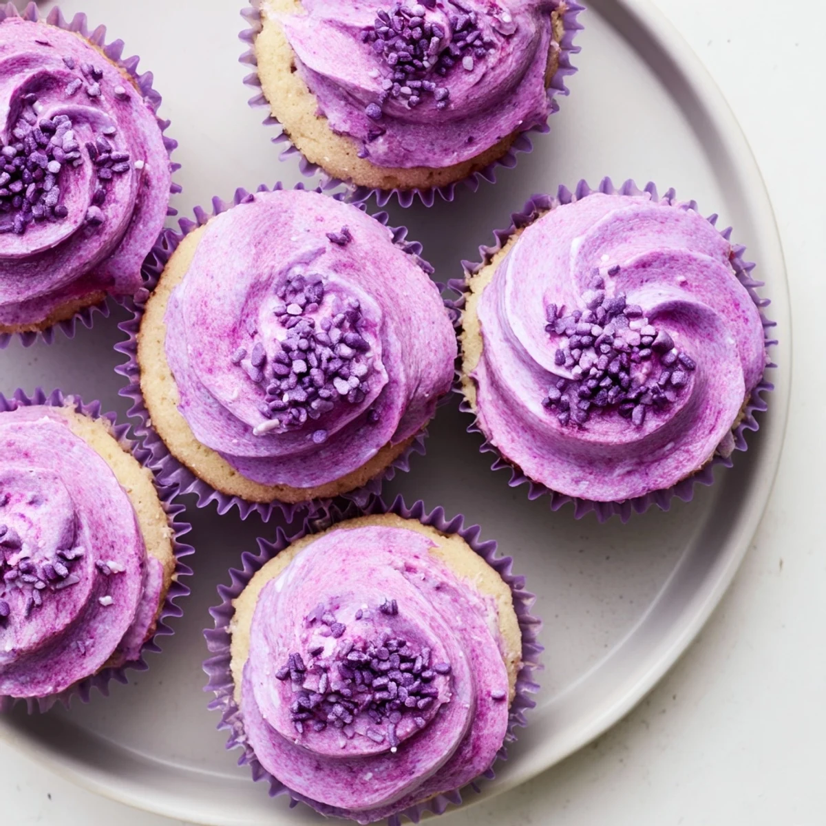 Vibrant grape soda cupcakes with tangy purple frosting and decorative sprinkles for parties