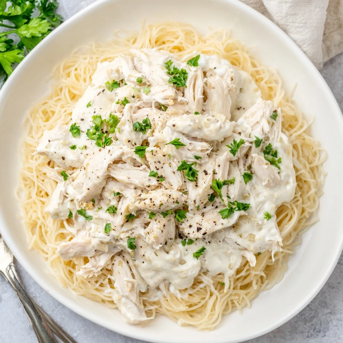 Creamy Crock Pot Angel Chicken served over angel hair pasta with golden sauce