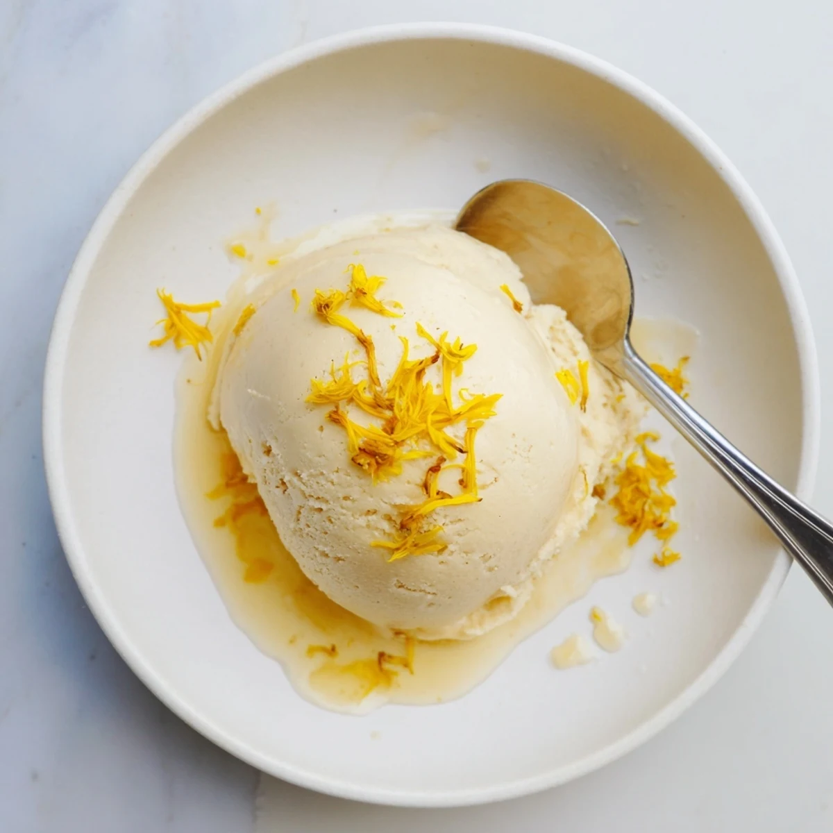 Velvety homemade dandelion honey ice cream garnished with edible flowers on summer plate