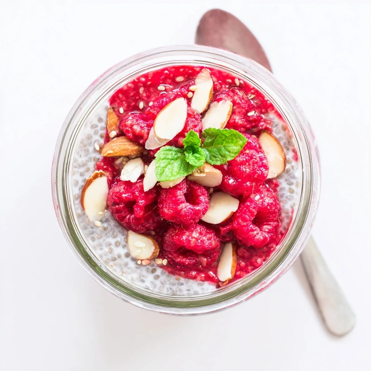Creamy chia pudding layered with mashed raspberries and topped with fresh berries