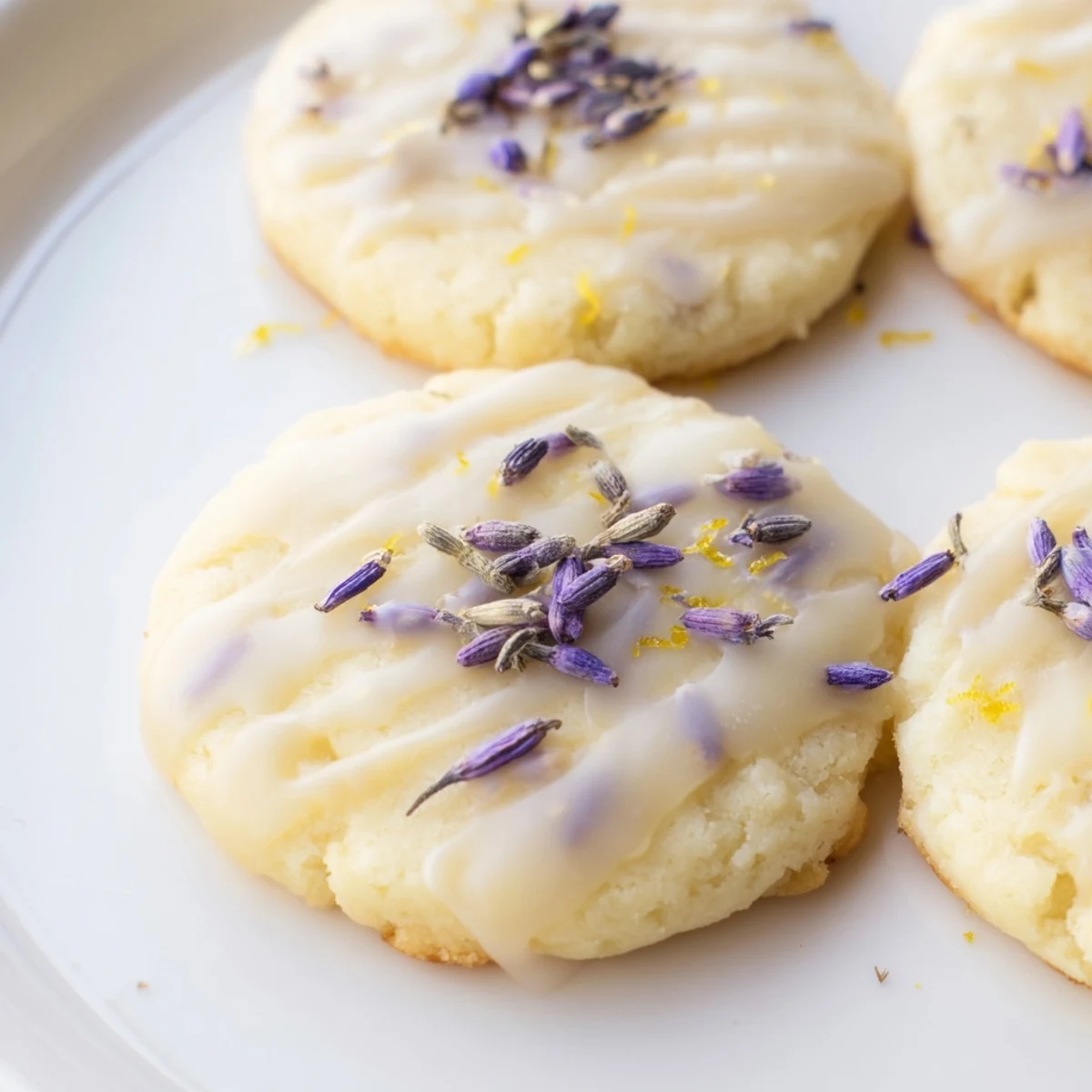 Lemon lavender shortbread cookies with glossy white icing drizzled on golden buttery rounds