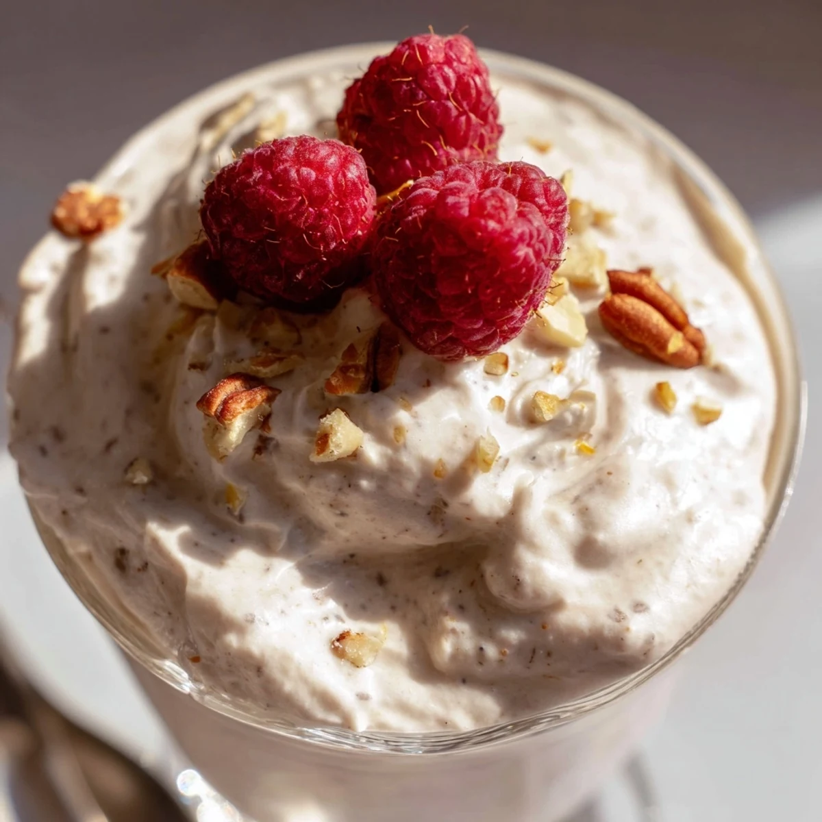 Creamy keto cheesecake fluff piled high in a glass topped with fresh red berries