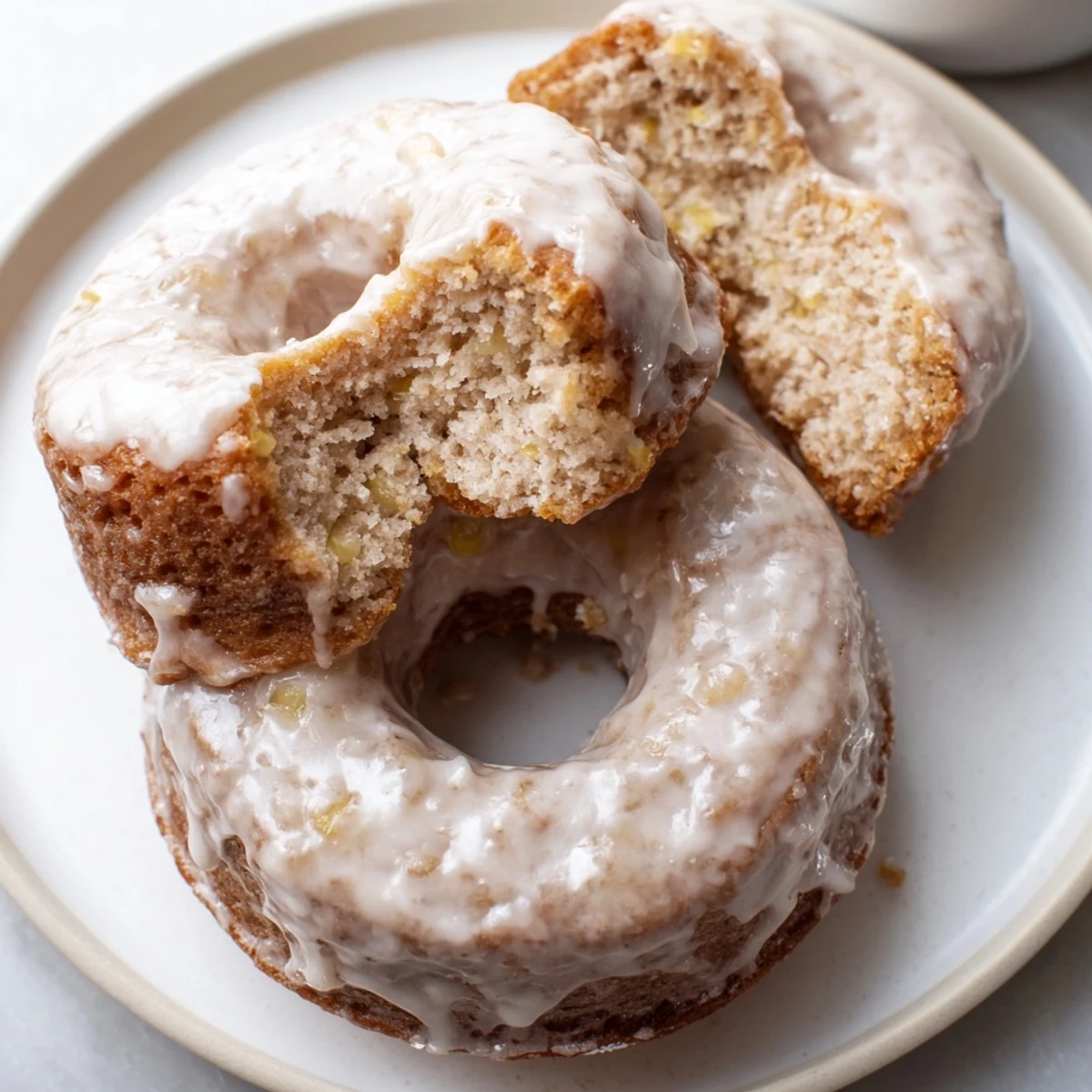 Banana Donuts with golden tops, tender crumb, glazed and resting on rack