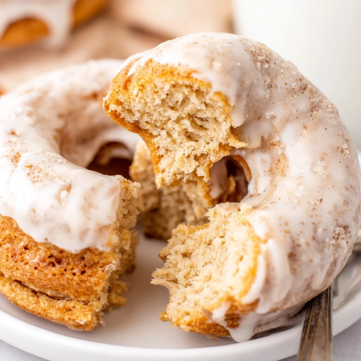 Stacked Banana Donuts drizzled with vanilla glaze, soft, cake-like texture visible