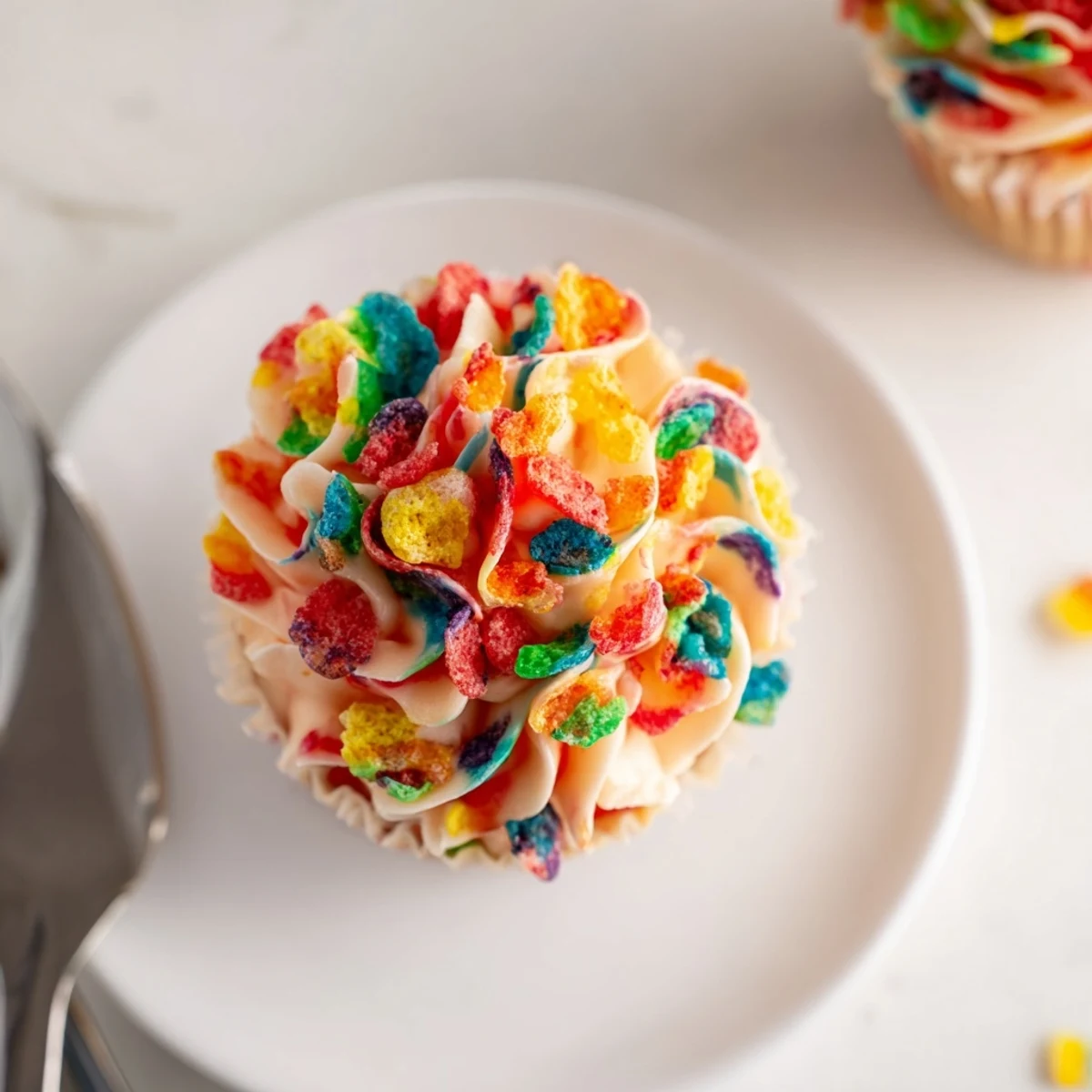Smooth buttercream frosting studded with rainbow Fruity Pebbles on a frosted cake