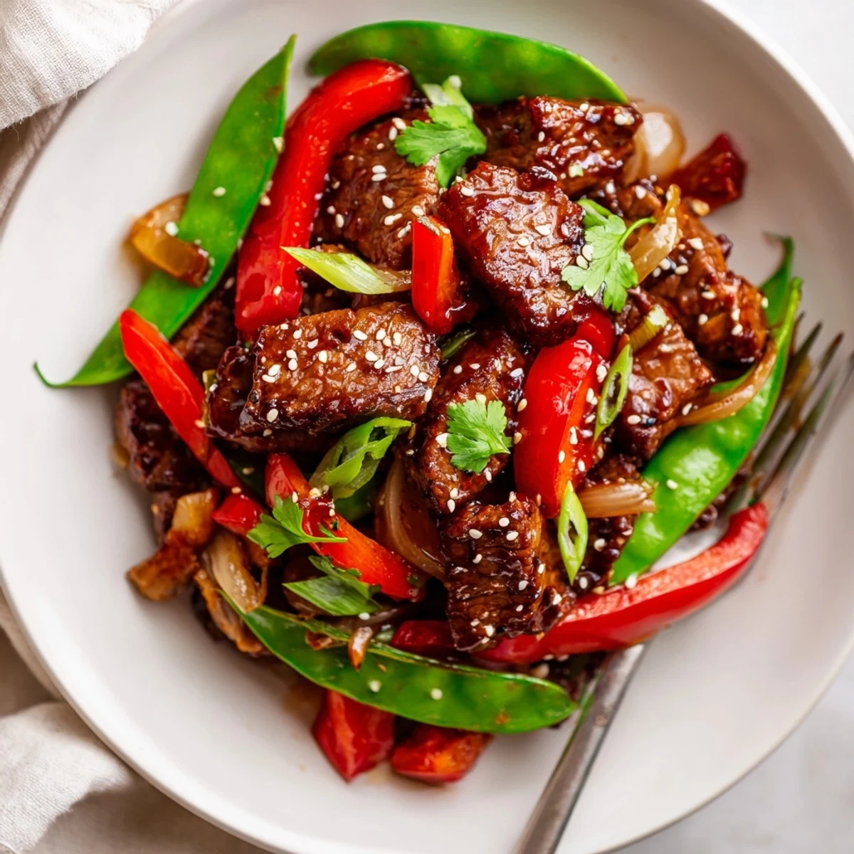 Tender pan-seared Asian-inspired cube steak topped with sesame seeds and fresh cilantro