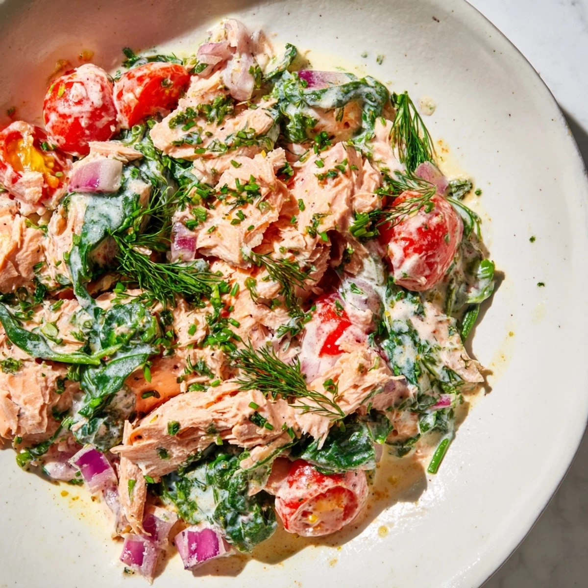 Healthy creamy leftover salmon recipe served steaming in a rustic cast iron skillet.